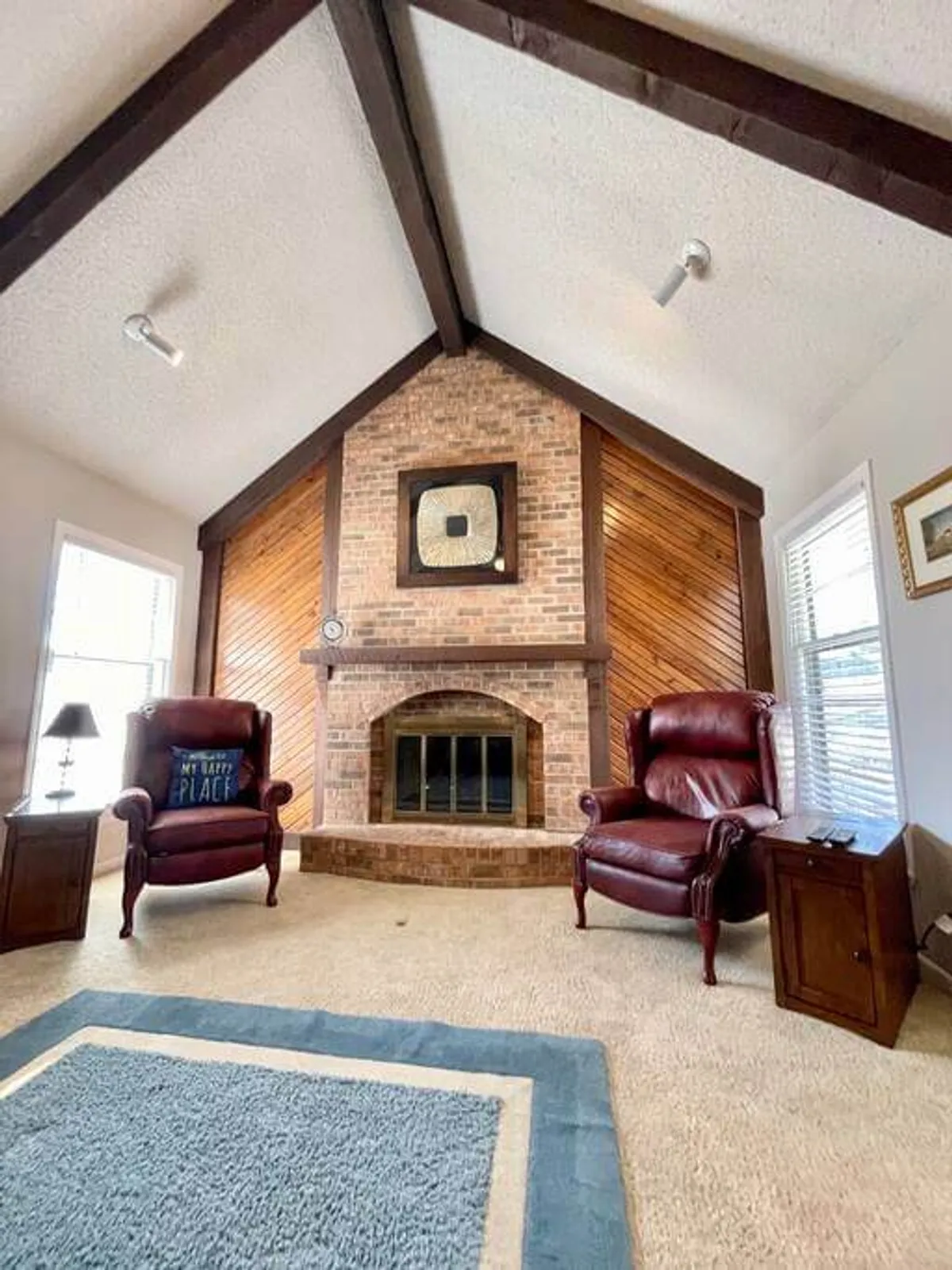 A cozy living area featuring a fireplace flanked by inviting red leather chairs and decorative wall art, exuding a welcoming and playful atmosphere. The room is arranged to encourage gathering, conversation, and appreciation of unique decor details.